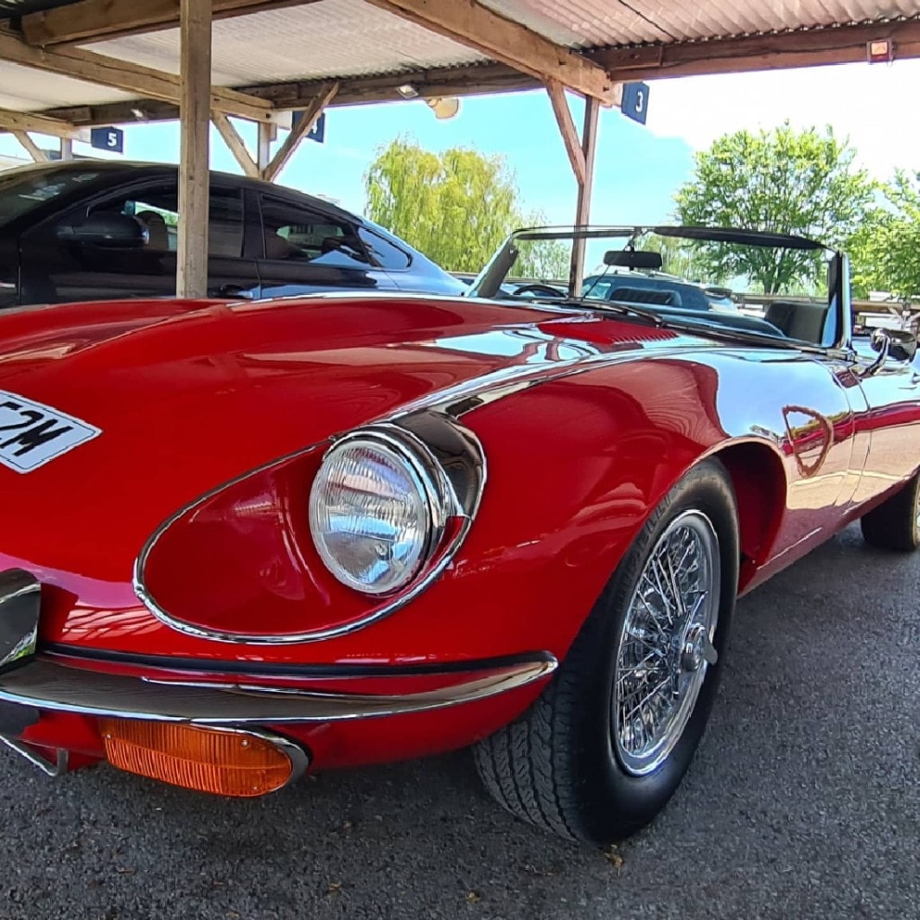 Classic red Jaguar E-Type roadster in the event paddock