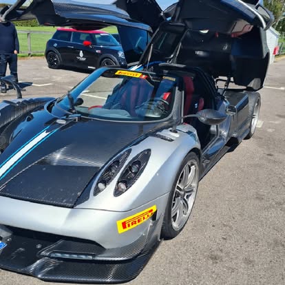 Pagani Huayra hypercar with doors open in the event paddock
