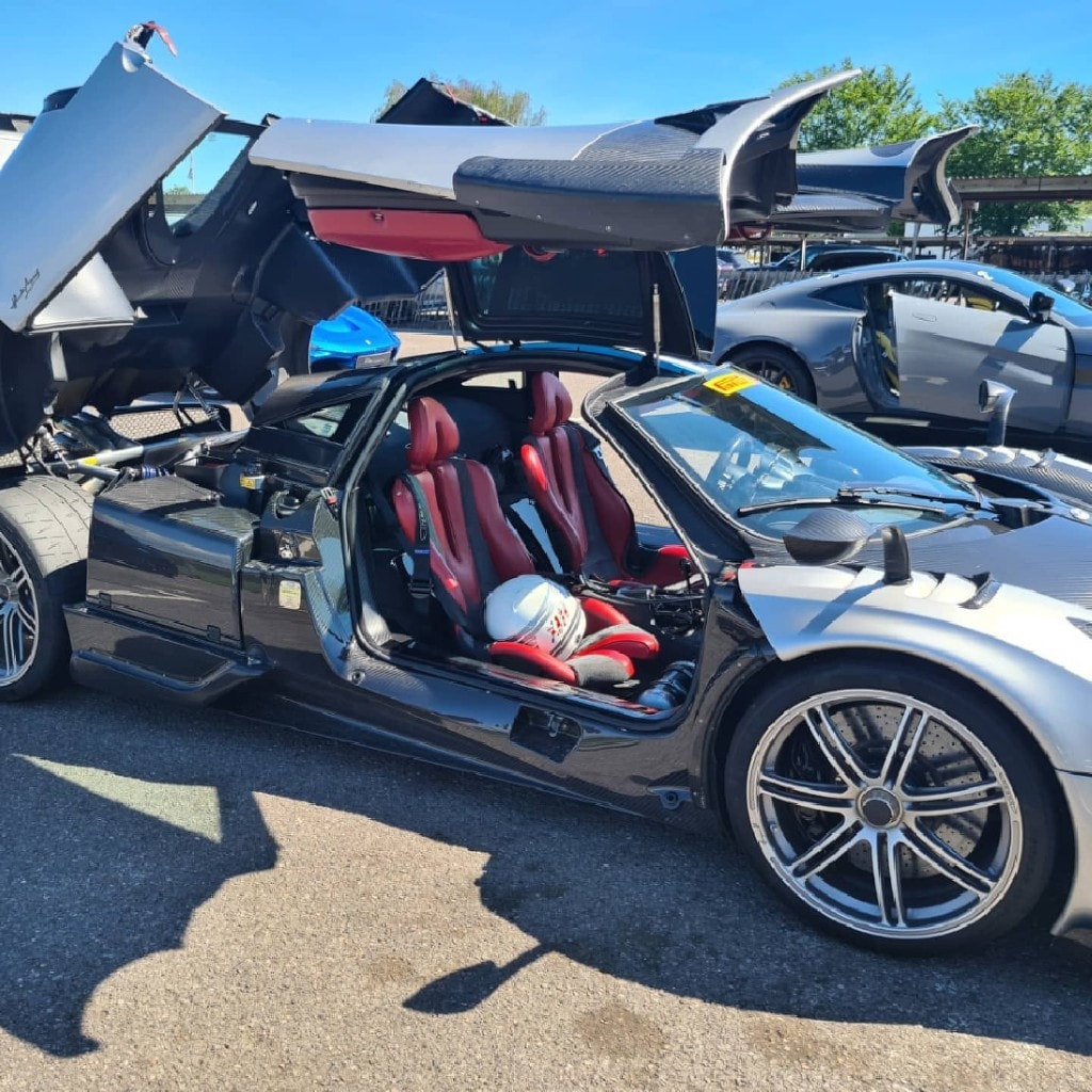 Pagani Huayra interior — red bucket seats, doors raised
