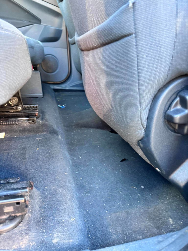MPV rear footwell before — fluff, debris and dirt embedded in carpet