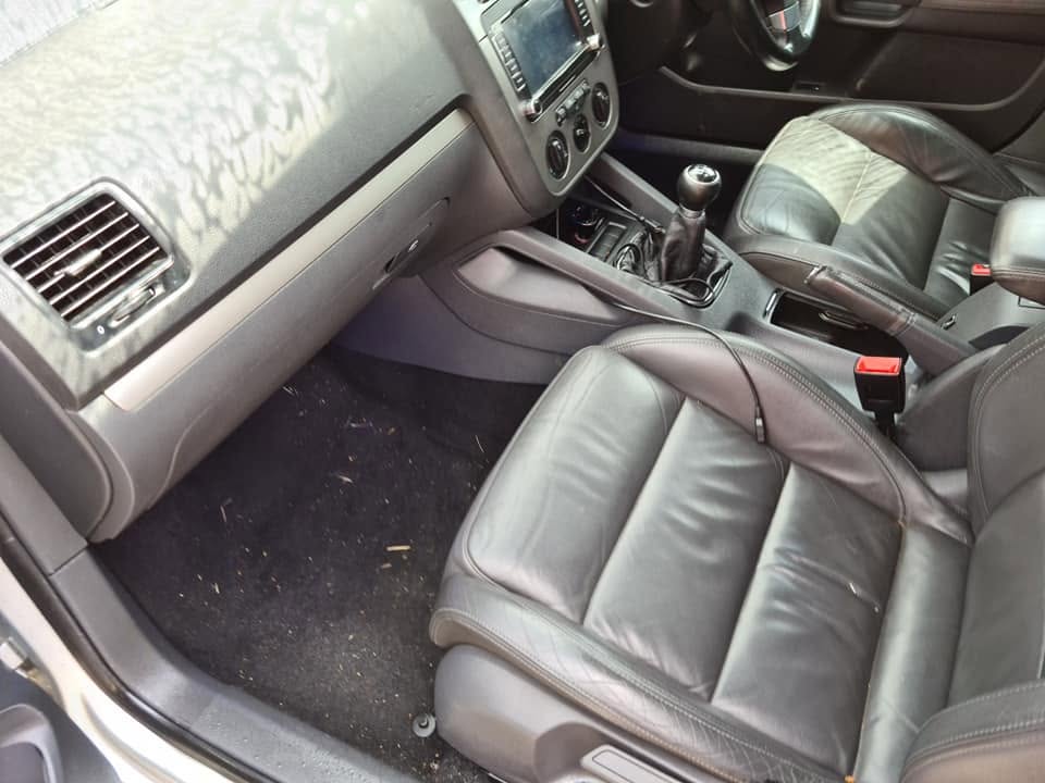 VW leather interior before — debris and grass on carpet, dull leather seats